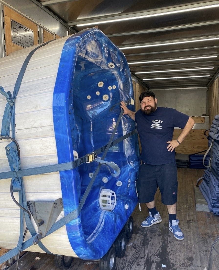 A Sloan's mover with a strapped hot tub loaded on specialty equipment inside a moving truck